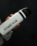A person in a gray fleece jacket holds a white insulated water bottle with a black lid. The bottle is printed with the text 'KARUNISTRENGTHSTUDIO FITNESS CLUB'.